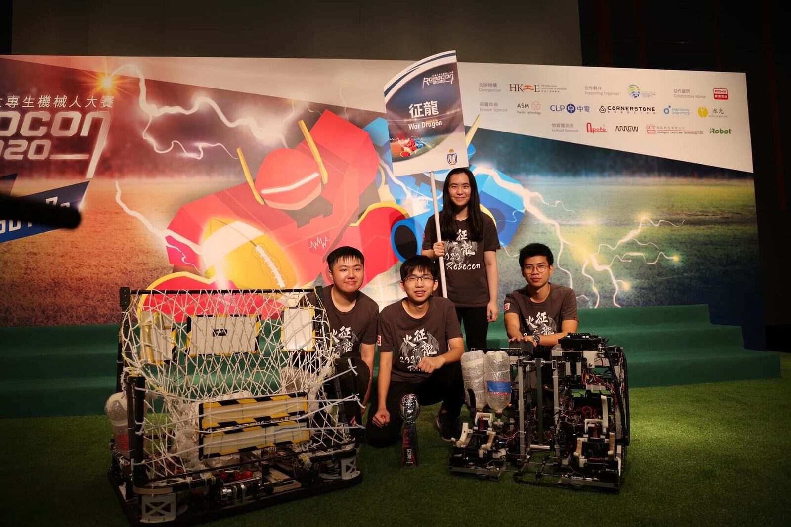 War Dragon members with robots and championship trophy